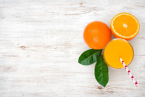 glass of orange juice and fruits on vintage wooden background - freshly squeezed orange juice imagens e fotografias de stock