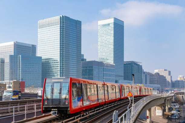 Cityscape of Canary Wharf in London Docklands light railway in London with Canary Wharf in the background commuter train photos stock pictures, royalty-free photos & images