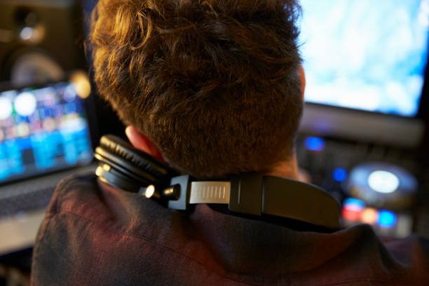 istock Young Man Mixing Music using Headphones 674646742