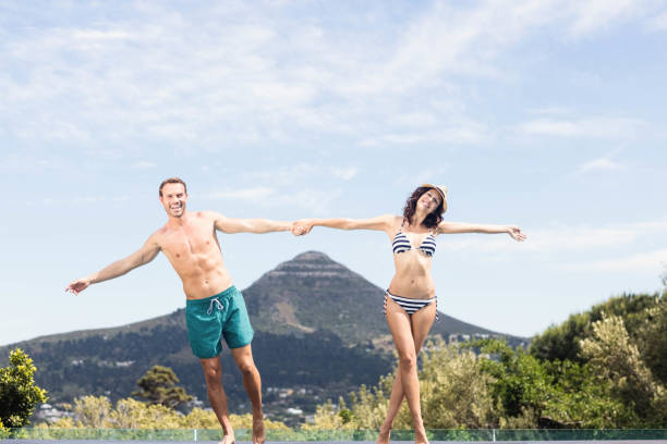 istock Young couple enjoying near pool 674647216