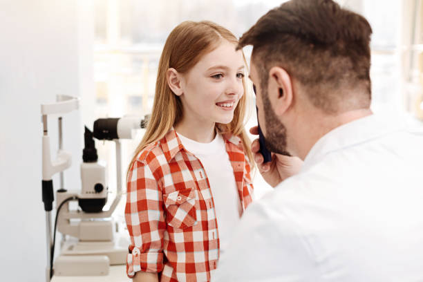 istock Competent cool doctor having a look at girls eyes 674650096