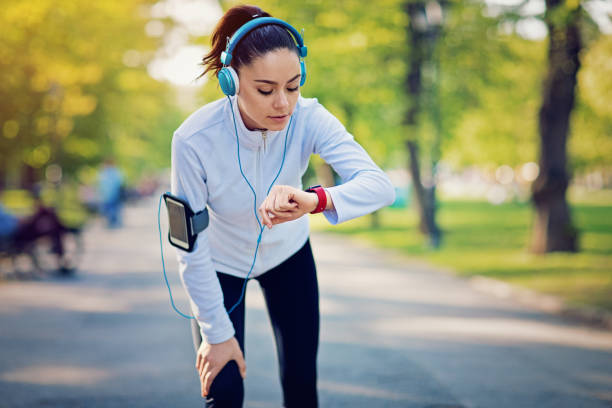 istock Running girl is checking her smart watch 674656444