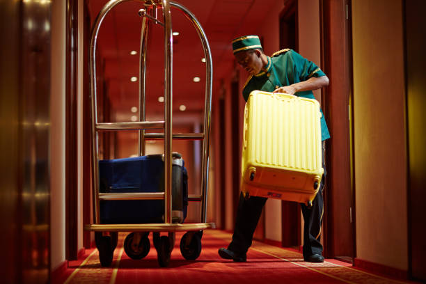 Porter at work Hotel servant taking out suitcase with baggage from hotel room bellhop stock pictures, royalty-free photos & images