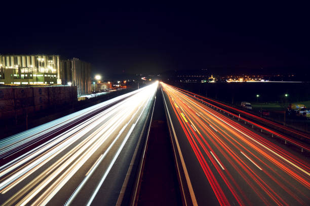 istock Light trails on highway with a industry building - slightly toned. 674659988