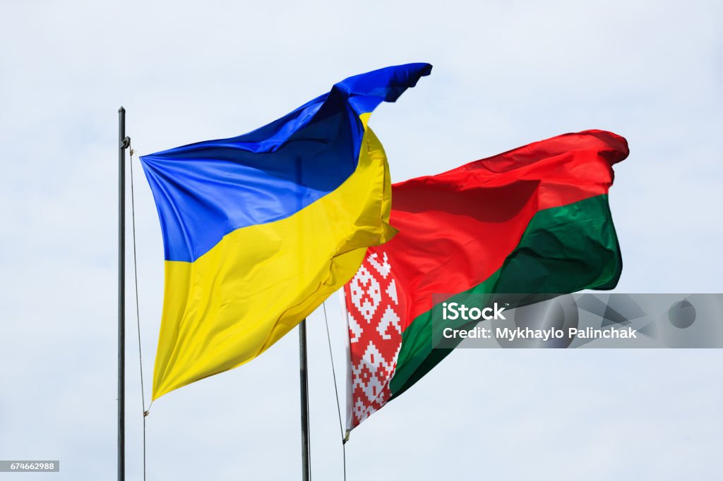 Waving flags of Ukraine and Belarus Symbol of friendship and partnership. Waving flags of Ukraine and Belarus on flagpoles against the sky Belarus Stock Photo