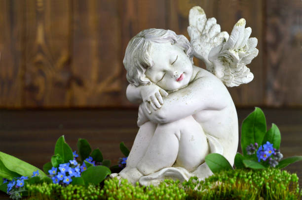 istock Angel and spring flowers on wooden background 674667000
