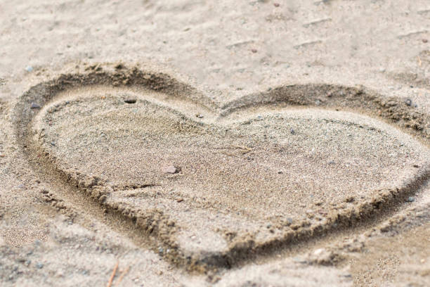 istock Heart drawn in the sand. Beach background. Top view 674670956