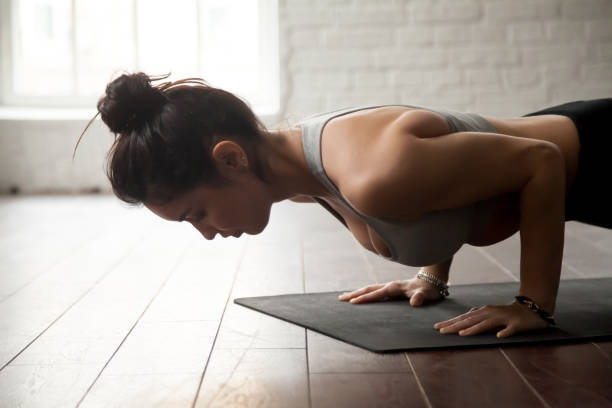 junge attraktive frau in chaturanga dandasana pose, loft studio - liegestütze stock-fotos und bilder