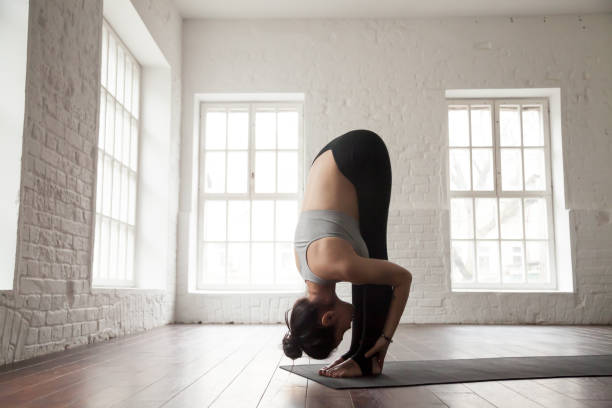 pose de mujer joven en la cabeza a las rodillas, estudio loft blanco - back somersault fotografías e imágenes de stock