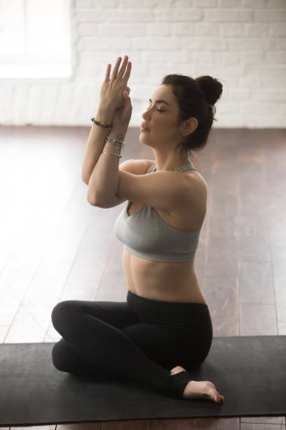 istock Young attractive woman sitting in Gomukasana, white loft studio 674673780