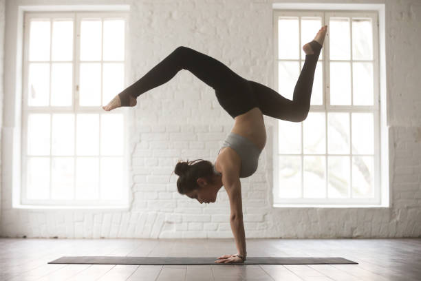 jeune femme séduisante dans adho mukha vrksasana pose, blanc studi - équilibre sur les mains photos et images de collection