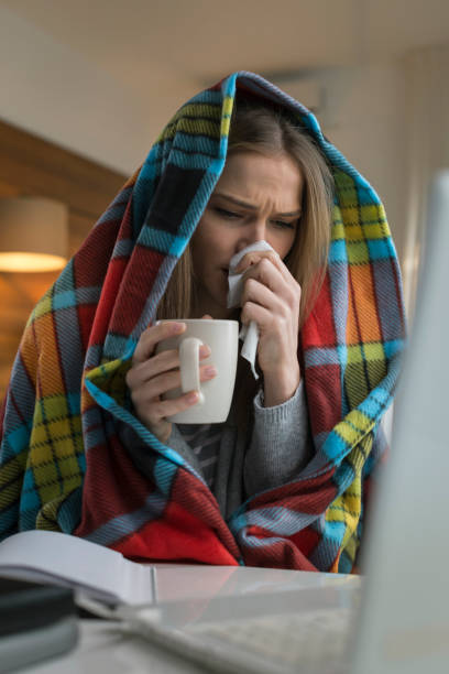 istock Woman which has a flu working from home on a laptop 674687880