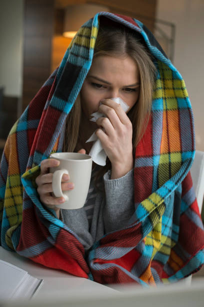 istock Woman which has a flu working from home on a laptop 674687980