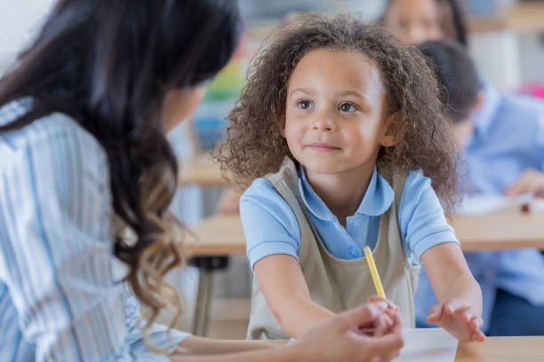 istock Attentive preschool student talks with teacher 674688216