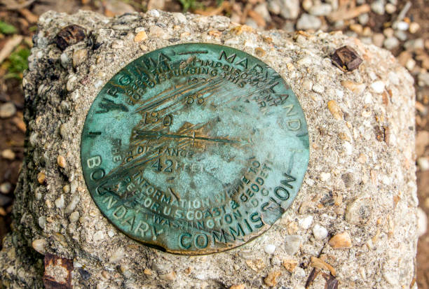 Marker Alexandria, VA, United States - April 26, 2017: Surveyors marker on the top of the old boundary stone on the shore of the Potomac River. This is the dividing line between the state of Virginia and the District of Columbia established her in 1799. fonts point photos stock pictures, royalty-free photos & images