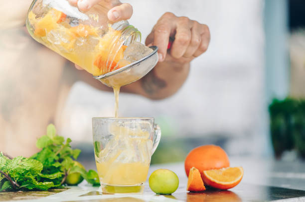 istock Man is cooking ice tea with orange and chrysanthemum at bar 674704794