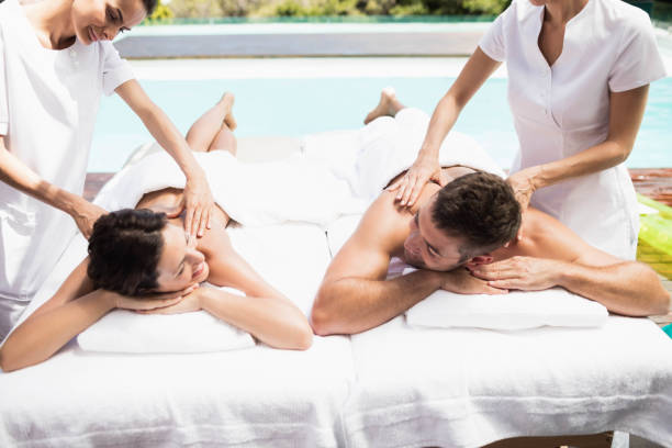 young couple receiving a back massage from masseur - massage table massaging sport spa treatment imagens e fotografias de stock