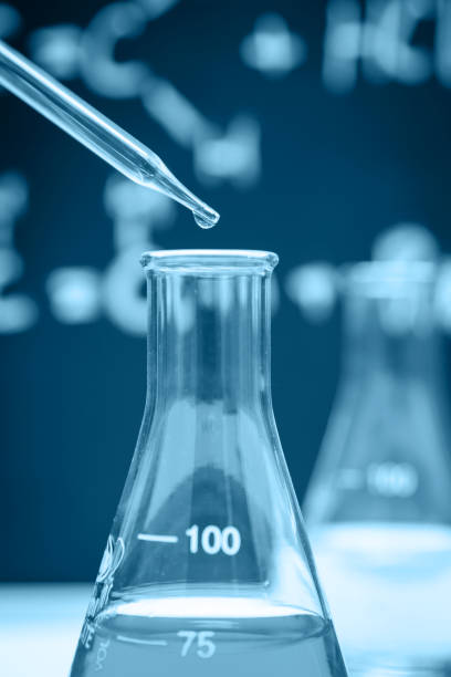 istock Dropping chemical liquid to flask 674708392