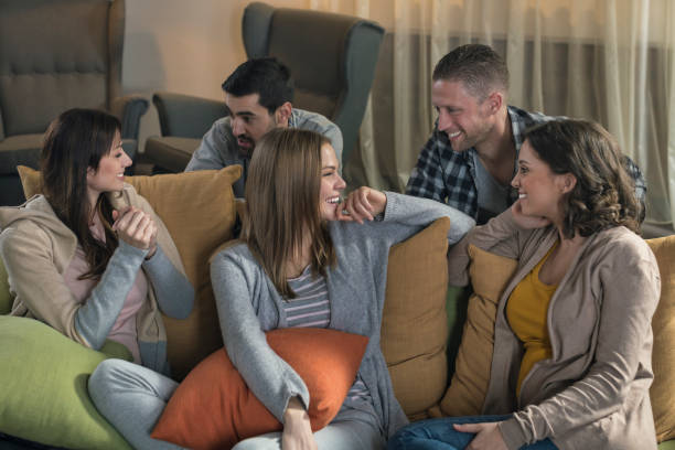 istock Group of friends sitting and talking on sofa at home 674708446