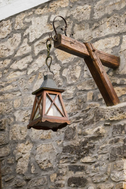 istock Old lantern hanging on the stone wall 674711716