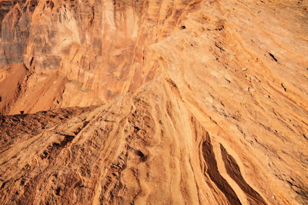 Navajo Sandstone Rock Strata Eroded Canyon Sandstone rock strata layers dating to Jurassic and Triassic periods in the canyon cliffs of the Southwest USA.  Full frame image of rock with eroded Navajo sandstone layers in the foreground and a view into a deep canyon in the background showing exposed older formations. chinle formation stock pictures, royalty-free photos & images