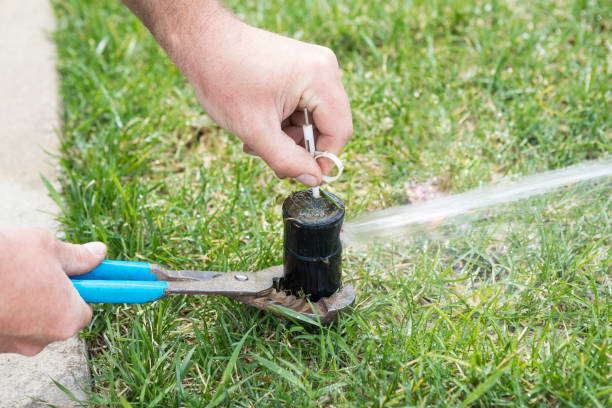 家の芝生灌漑システムのためのスプリンクラー ヘッド調整 - 園芸用散水機 ストックフォトと画像