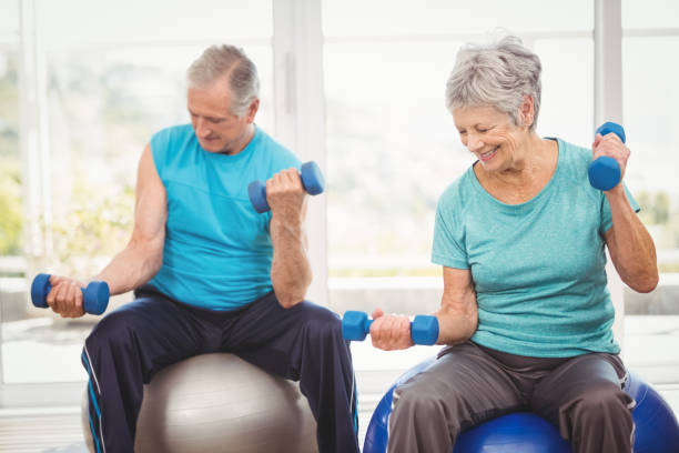 istock Smiling senior couple holding dumbbells while exercising 674720924