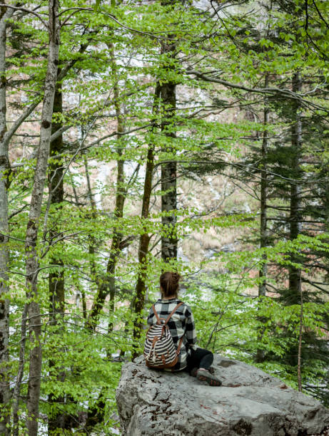 istock woman traveler sitting in forest 674724242