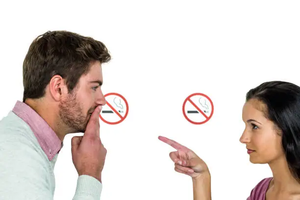 Couple with stop smoking signs on white screen