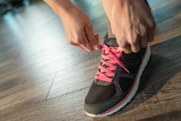 istock Woman tying shoelace at gym 674730128