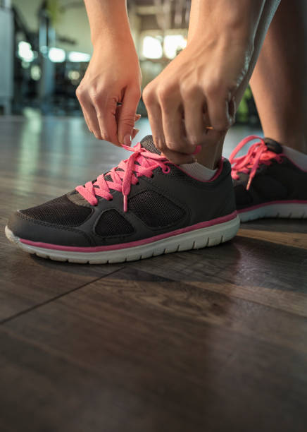 istock Woman tying shoelace at gym 674730256