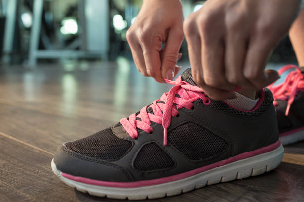istock Woman tying shoelace at gym 674730260