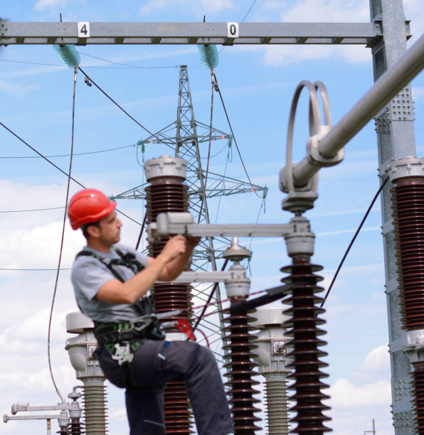 istock Electrician with protective workwear, hardhat and safety harness working 674733668
