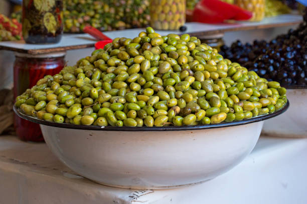 olives vertes dans un grand bol sur l’étal de nourriture au maroc - market stall spain fruit trading photos et images de collection