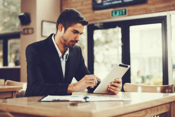 istock Young businessman using a digital tablet in cafe 674753412
