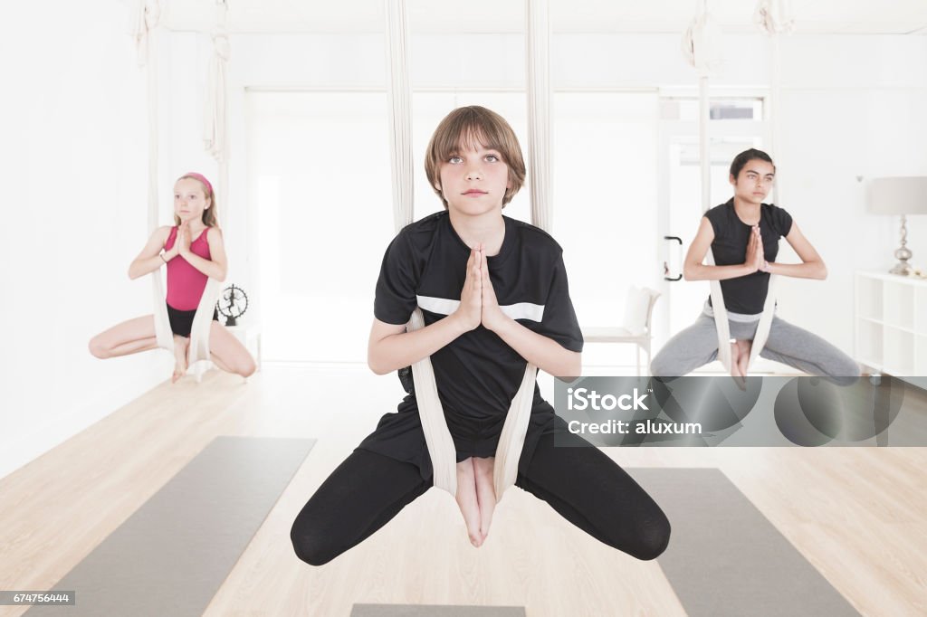 Aerial Yoga class for children Group of children practicing aerial yoga 10-11 Years Stock Photo