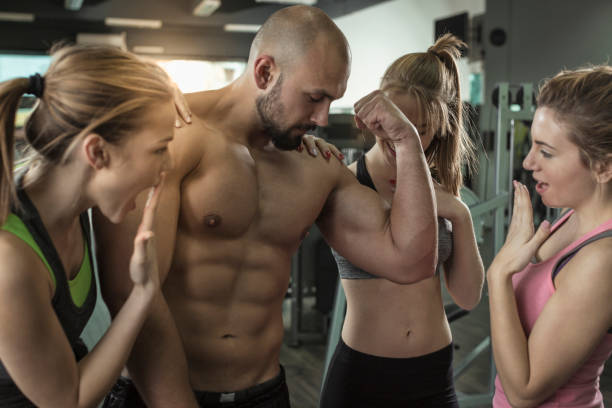 istock Three women admiring mens big muscles at gym 674756878