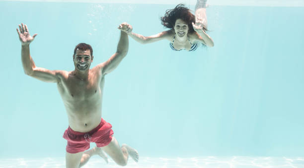 istock Couple enjoying underwater in swimming pool 674765466