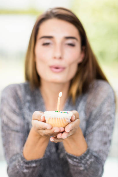 istock Beautiful woman holding birthday cupcake 674766300