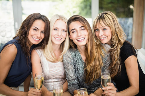 Portrait of beautiful women smiling and having drinks at the party