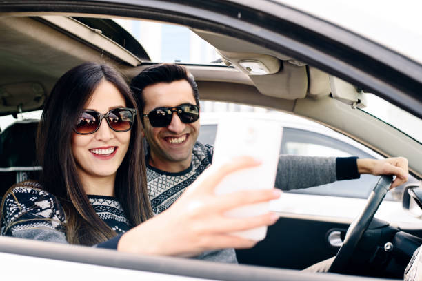 istock Young smiling couple on road trip taking selfie 674769750