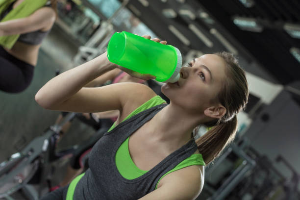 istock Young woman drinking water after hard training 674772332