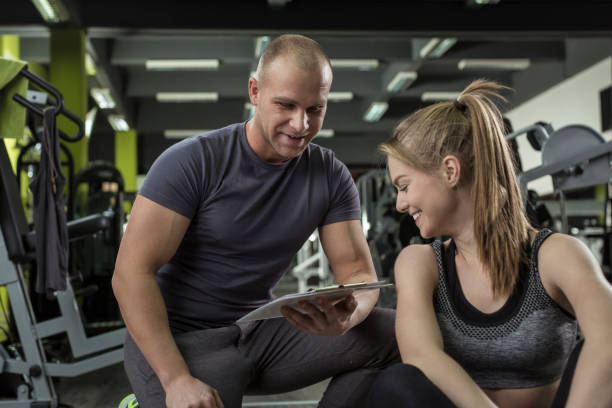 istock Woman working with personal trainer in gym 674779080