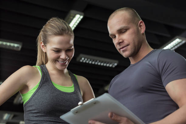istock Woman working with personal trainer in gym 674779468