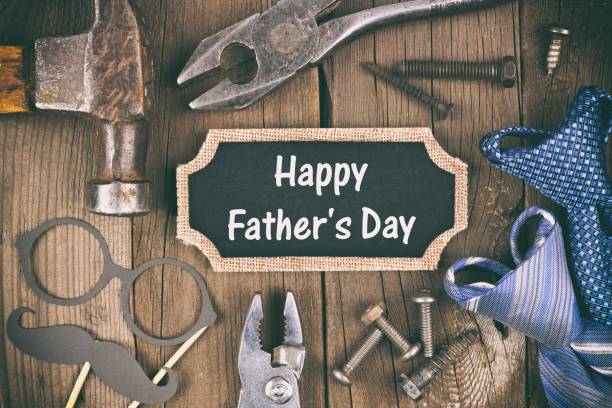istock Happy Fathers Day chalkboard tag with tool, gift and tie frame on wood 674782378