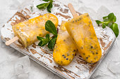 Homemade frozen popsicles with fresh mango and passion fruit