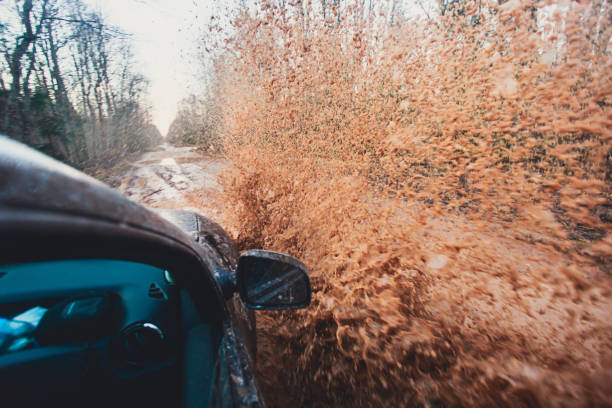 istock Suv 4wd car rides through muddy puddle, off-road track road, with a big splash, during a jeeping competition 674796648