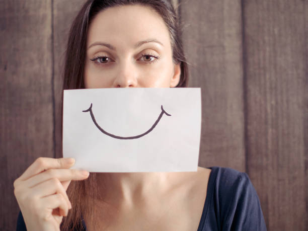 istock Smiling girl with a smile painted on paper 674797356