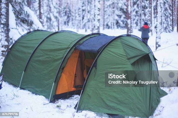 A Process Of Camping In Winter Forest Setting A Tent Covered In Snow Making A Bonfire Campfire And Cooking Food With Portable Gas Cooker And Fire Snowy Landscape Stock Photo - Download Image Now