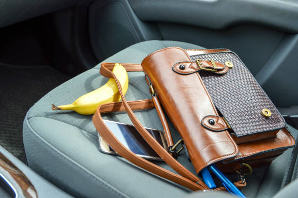 bolso y accesorios establecidos en el asiento del pasajero del coche con un plátano - bolsa objeto fabricado fotografías e imágenes de stock